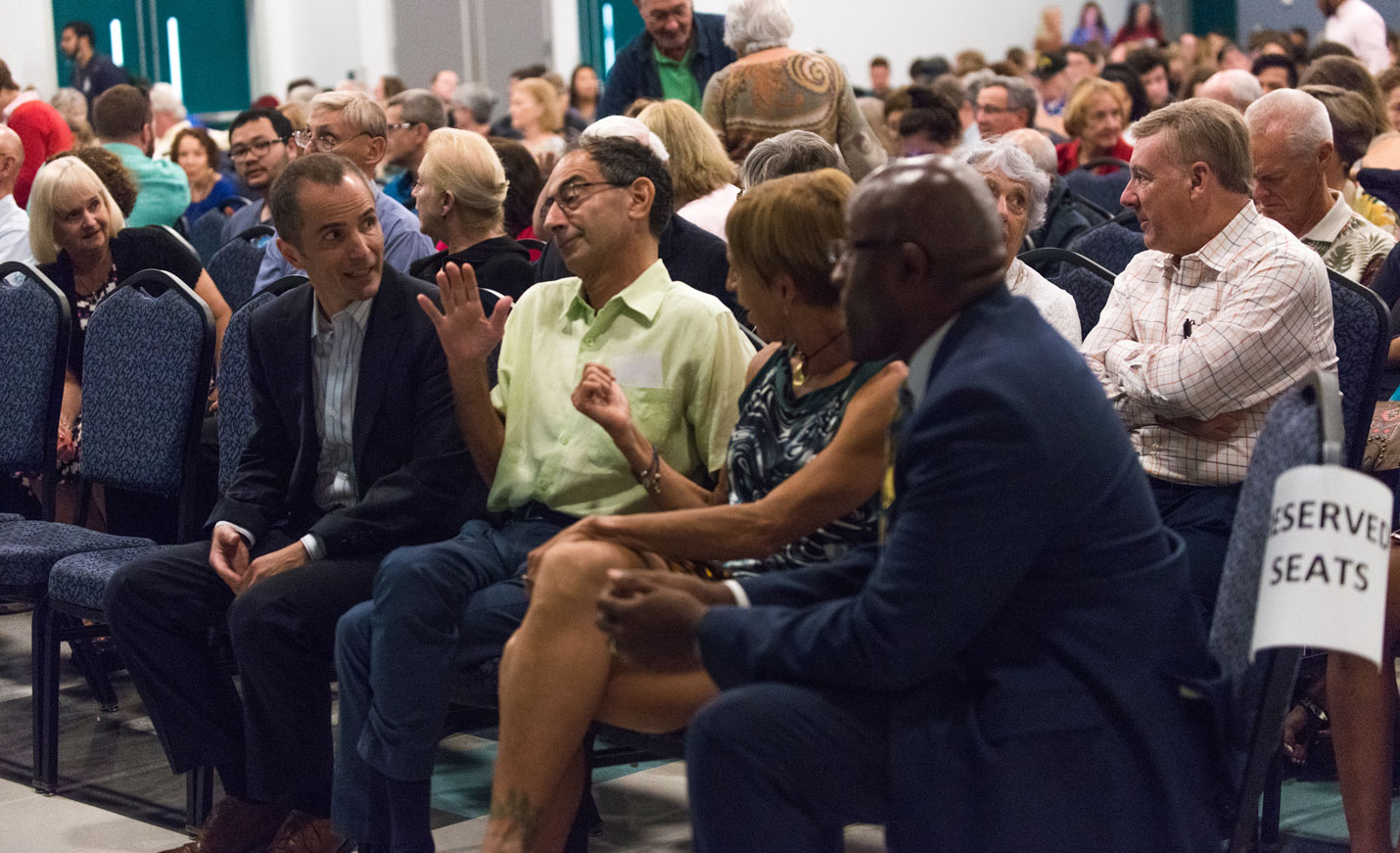 Audience sitting in front row of conference having a discussion