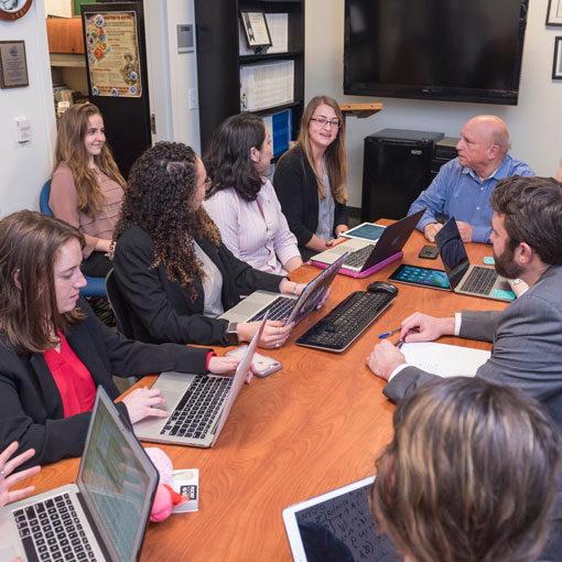 People sitting around a table with laptops