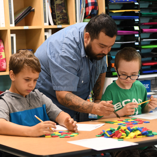 Teacher helping two students with an assignment