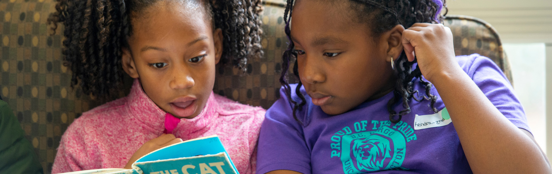 Two kids reading a book together