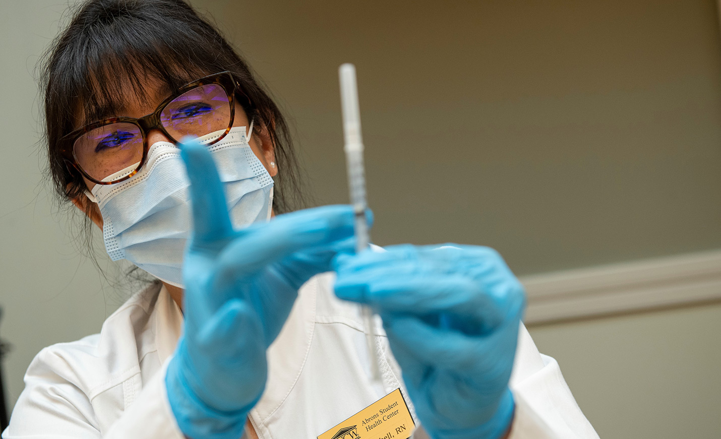 A nurse readies a vaccine.