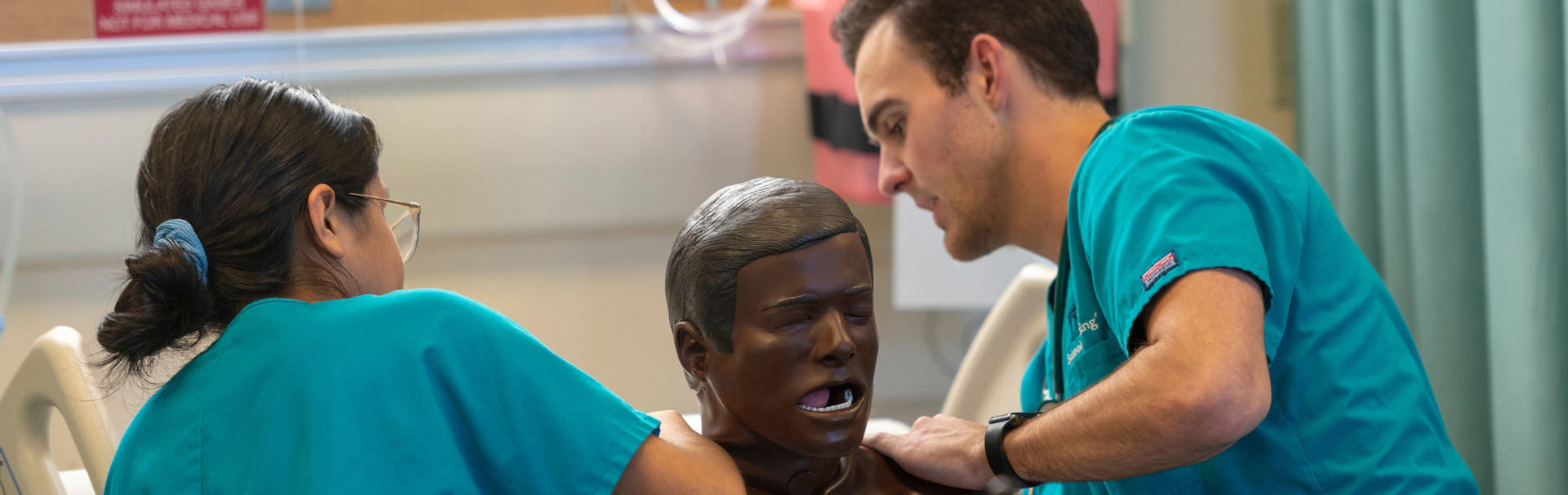 Two nurses running tests on a dummy