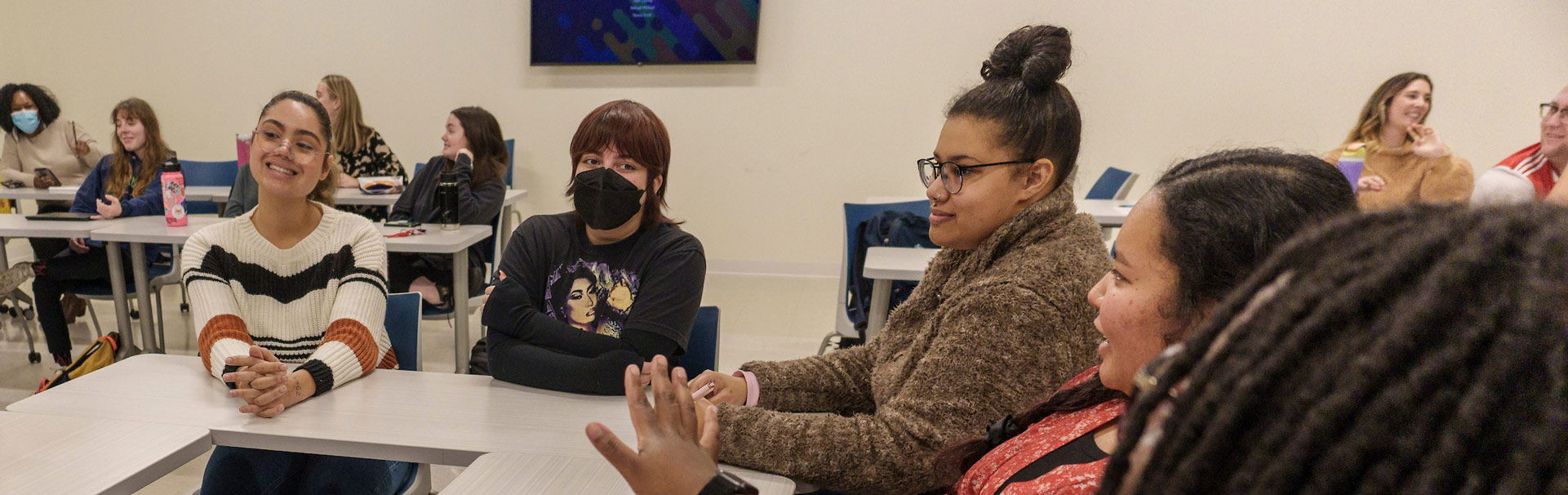 Students in a classroom talking around a table