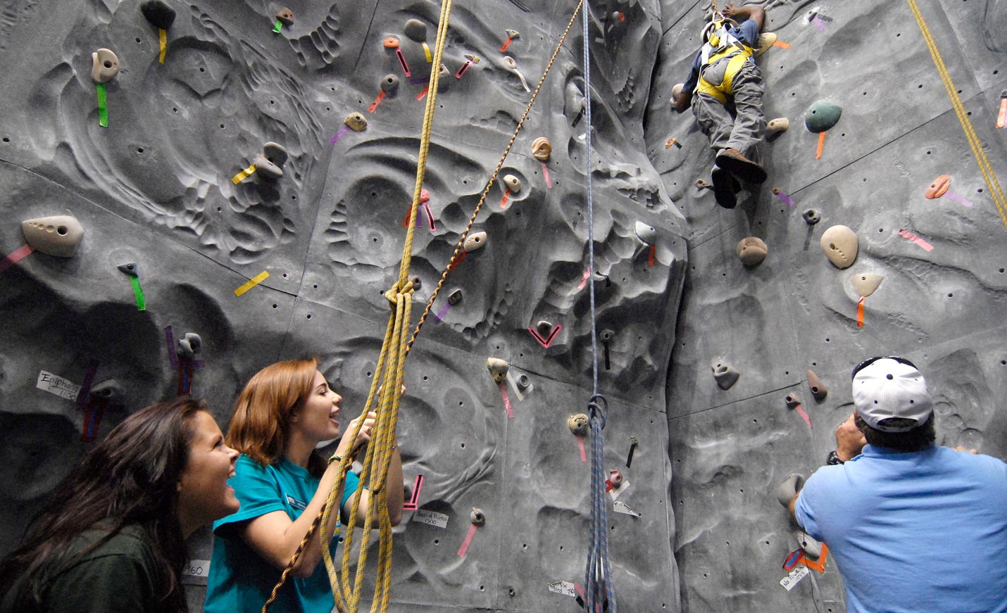 Recreation therapy students assist a climber on the climbing wall.