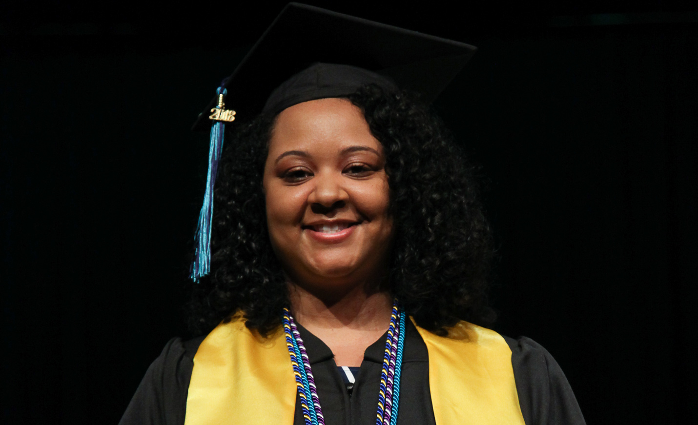 A social work student in her cap and gown, ready for commencement.