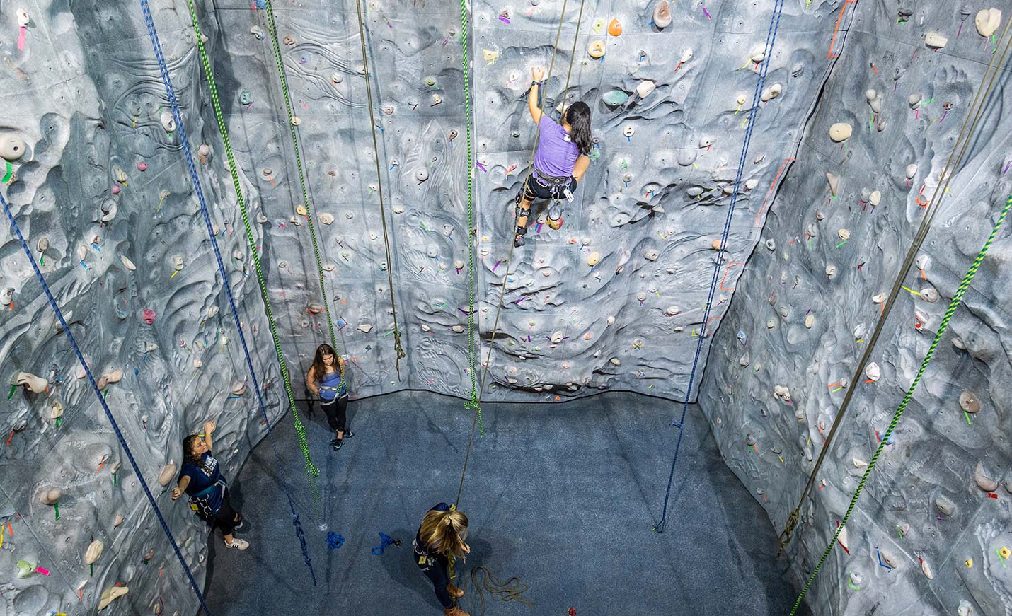 Students climb the rock climbing wall in the Student Recreation Center on campus at UNCW.