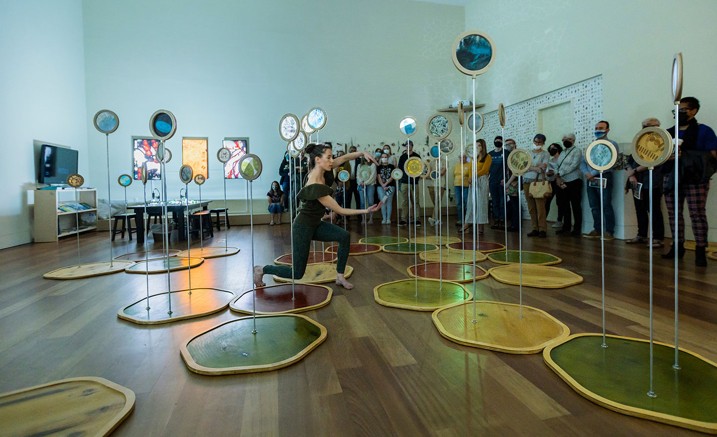 Person doing a performance at an art exhibit with audience