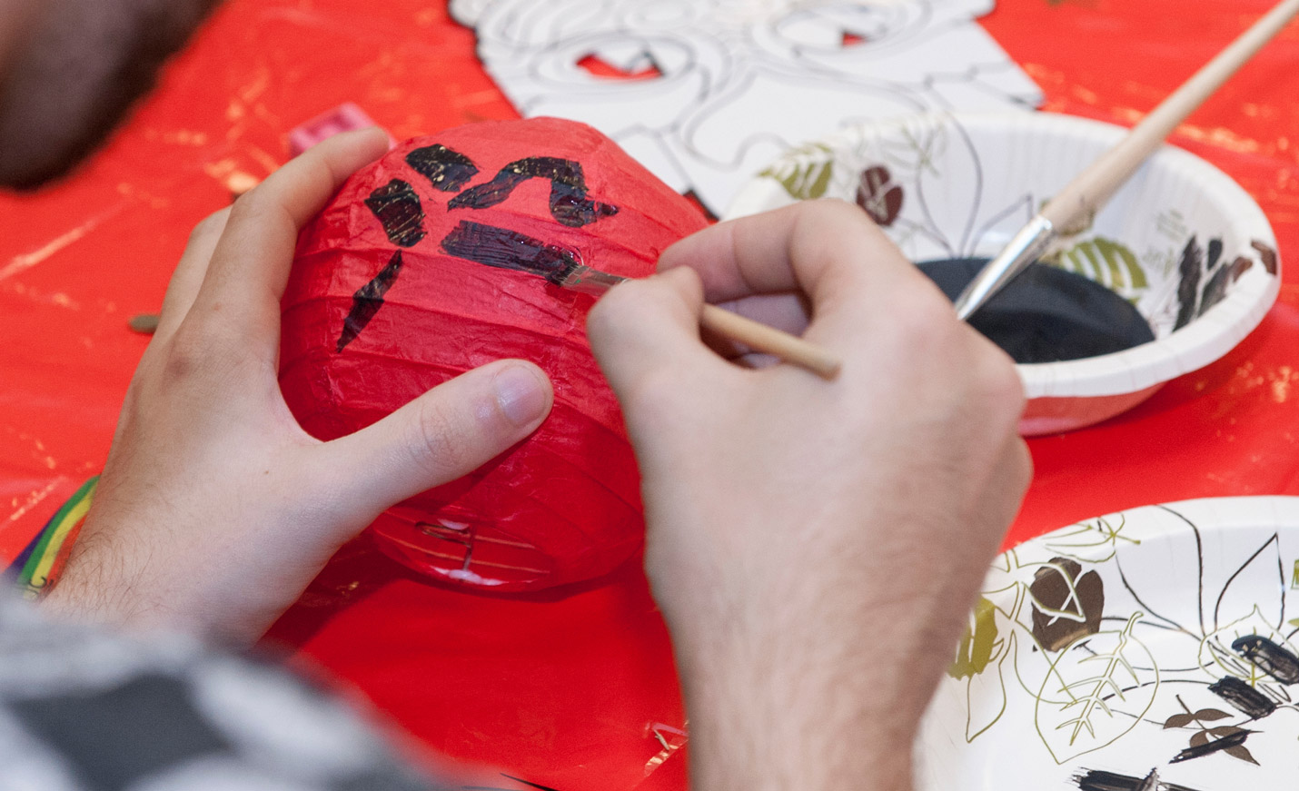 student painting on a paper lantern