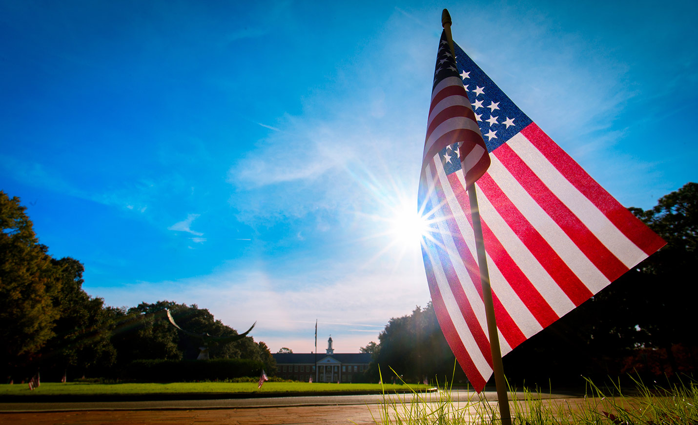 American flag flying near Seahawk statue at front of campus