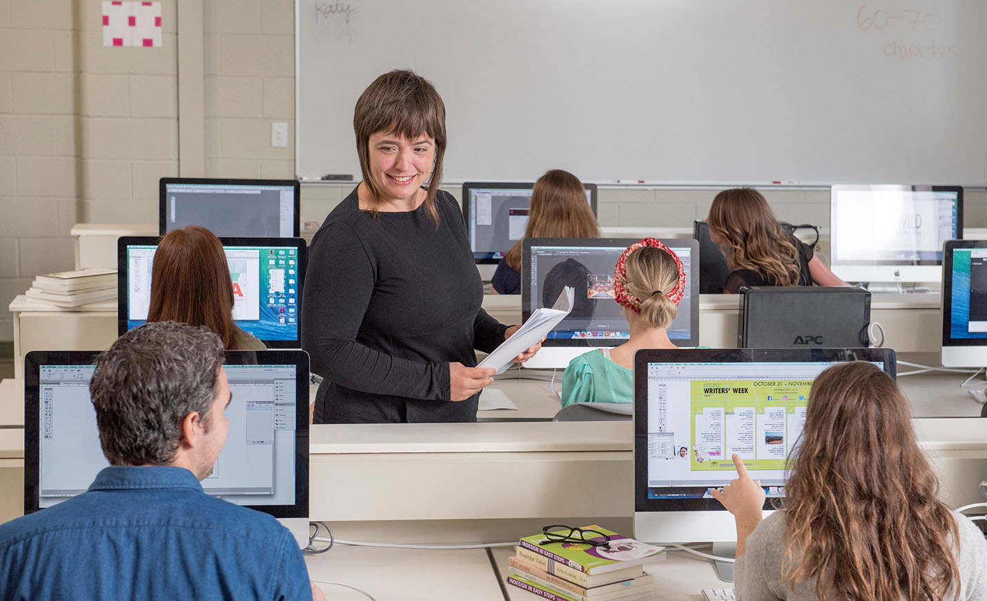 faculty member talking with students in Publishing Laboratory