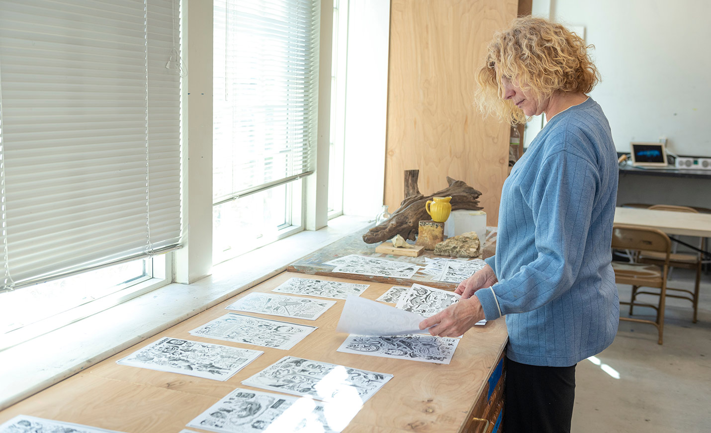 faculty member looking at art illustrations