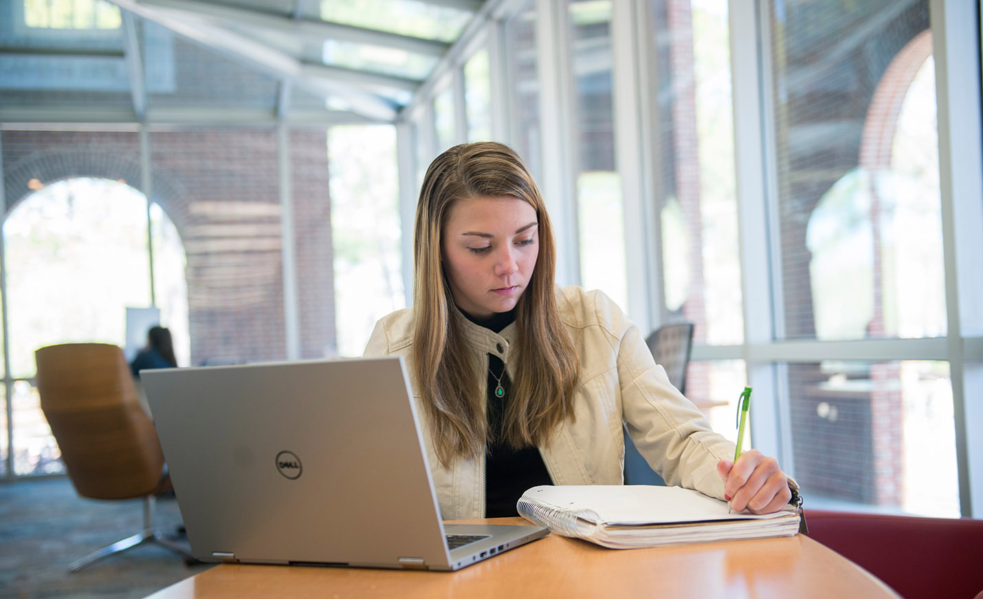 student working on computer and taking notes