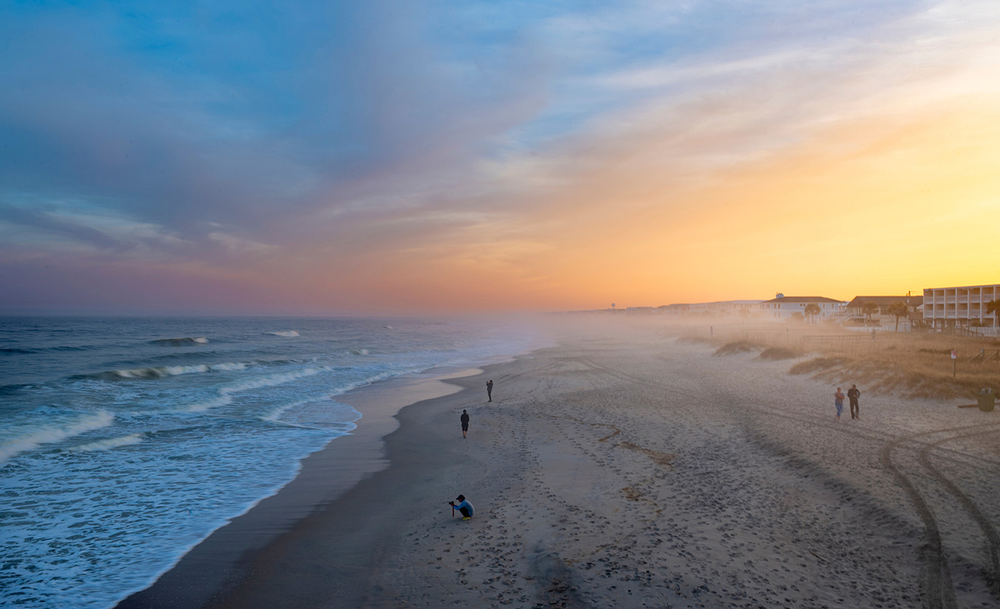 people on a beach at sunset