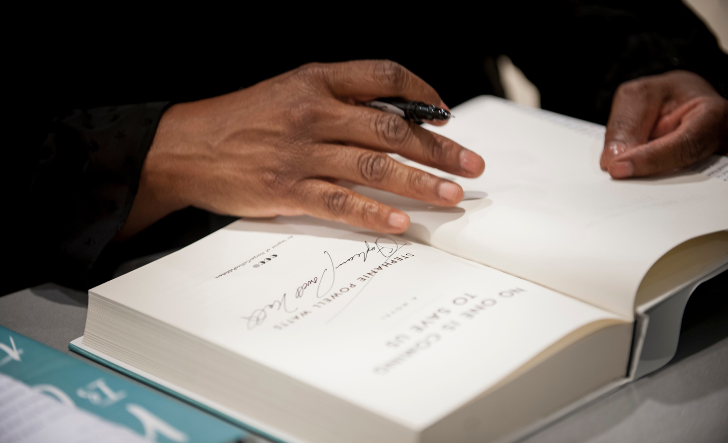 author signing autograph on book