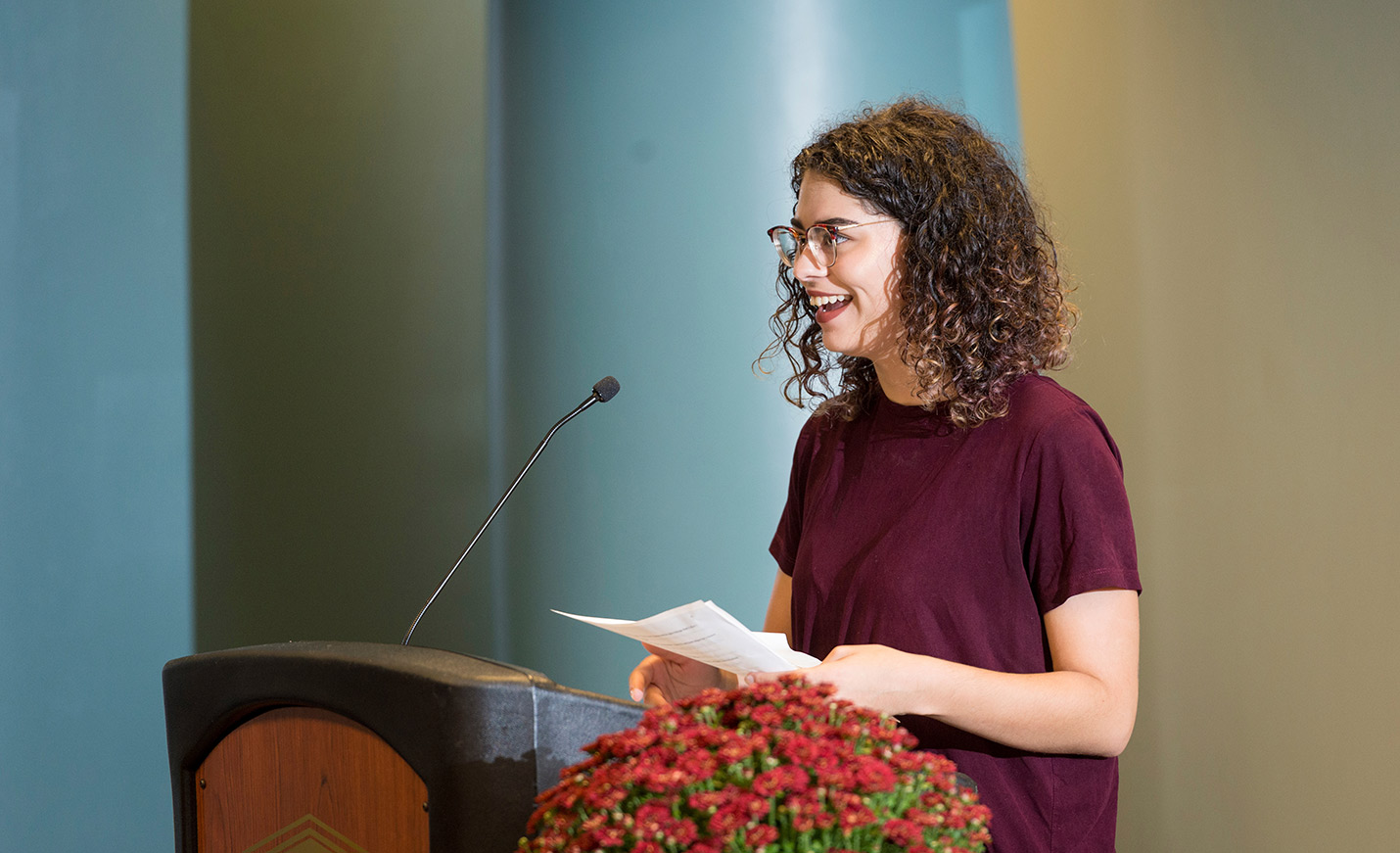 Smiling student reads from a podium