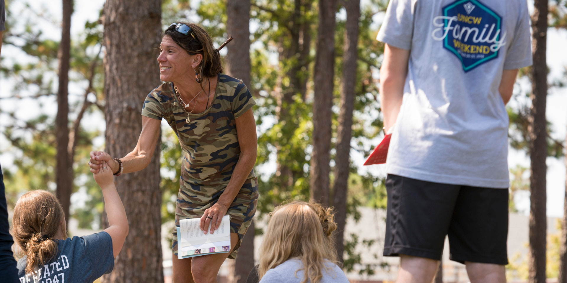 A professor gives a student a high five while teaching outside