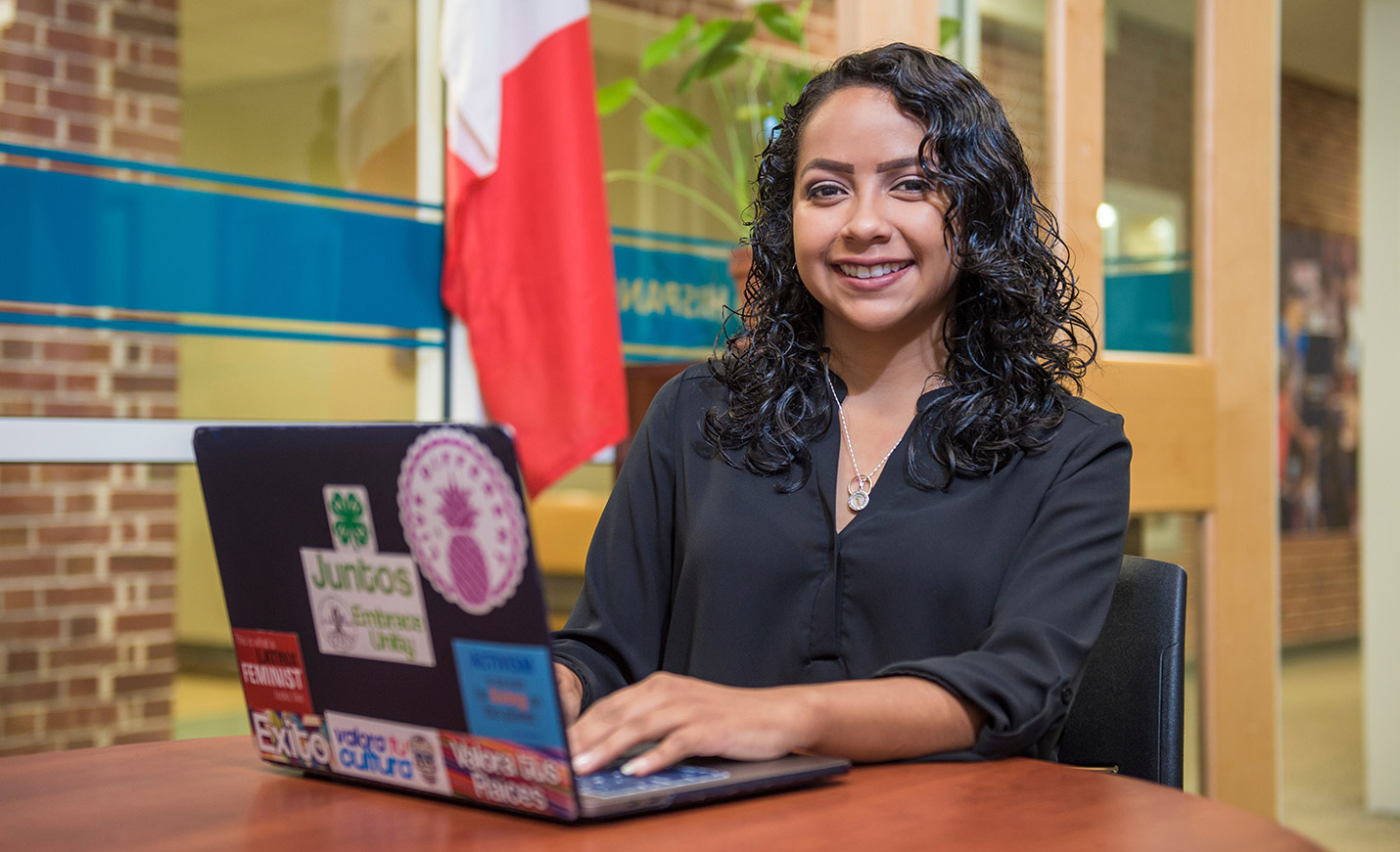 smiling student sitting at a laptop