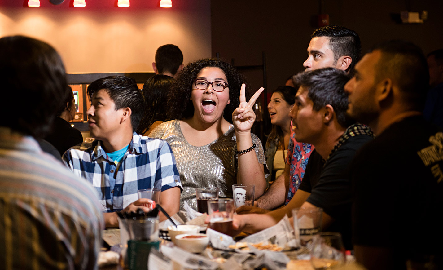 Student showing peace sign at a gathering
