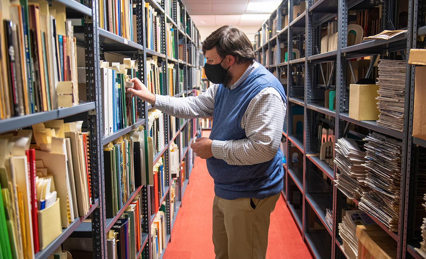 faculty member looking through the stacks in UNCW Library
