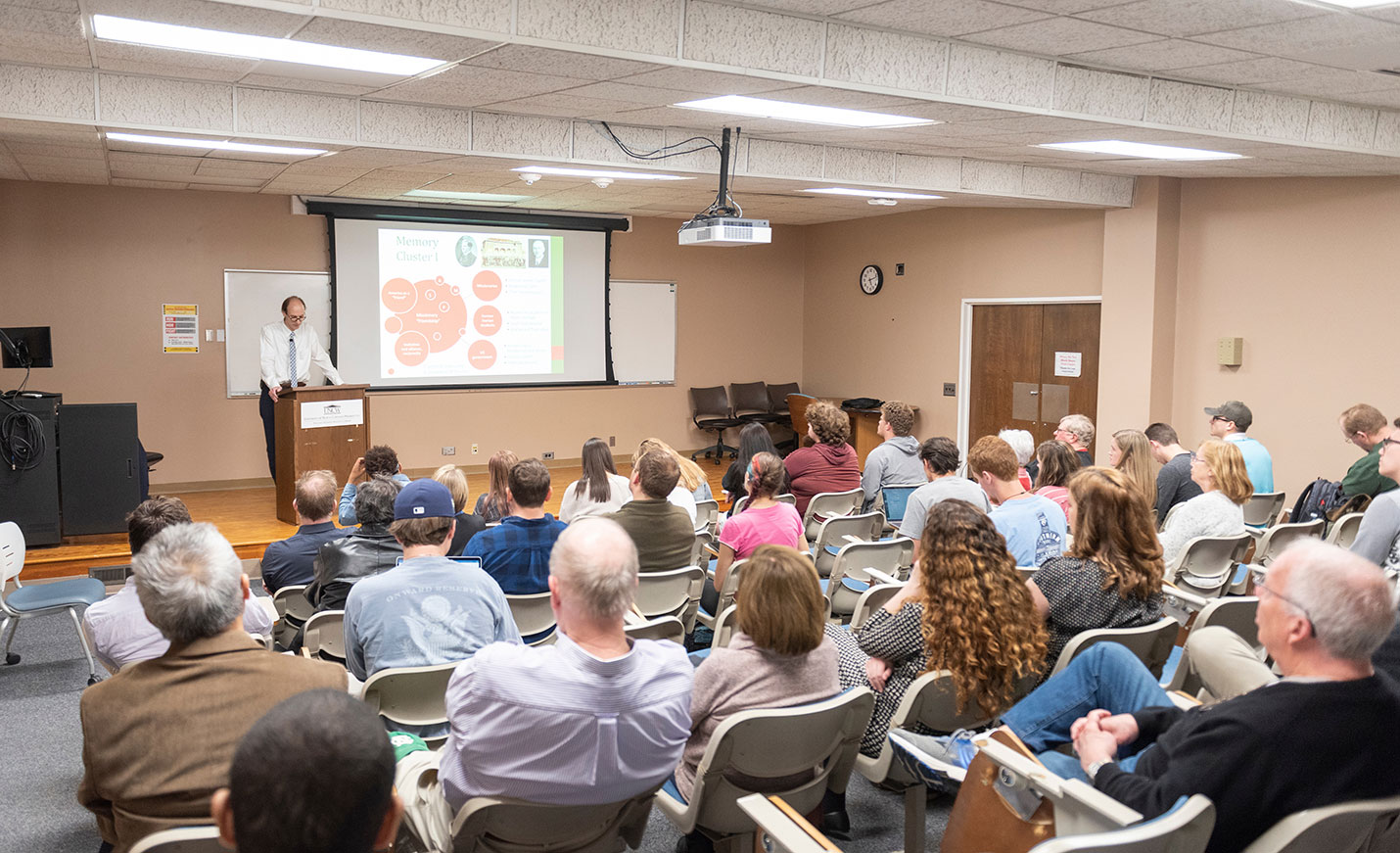 faculty member present a lecture and PowerPoint presentation to a class.