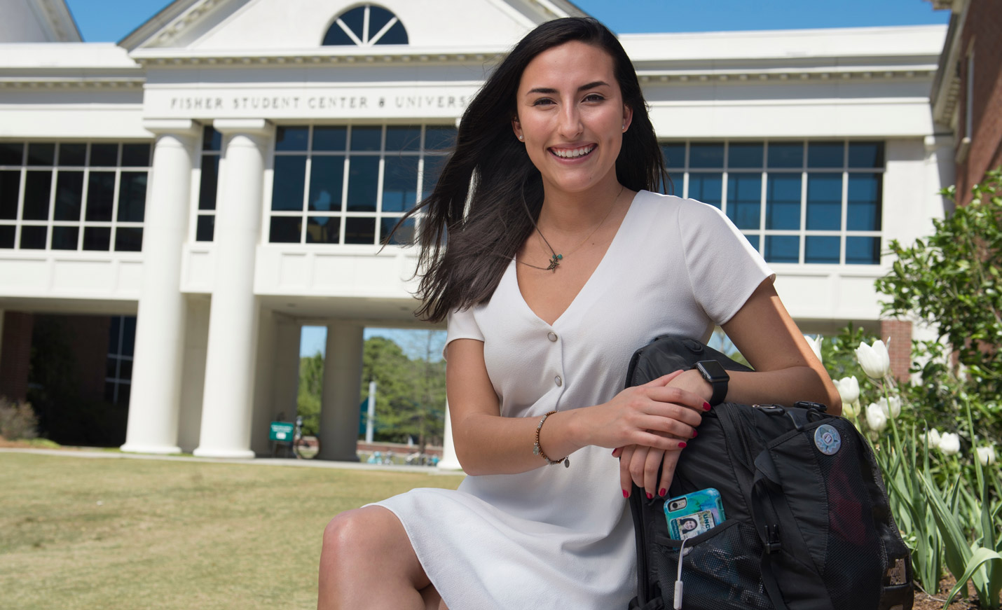 student sitting on a bench in front of Fisher Student Center