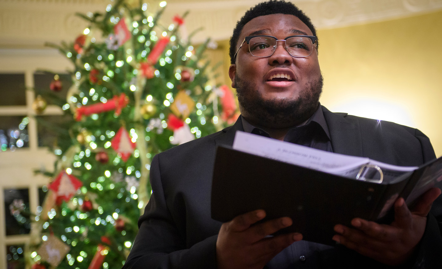 A singer performs in front of holiday decorations