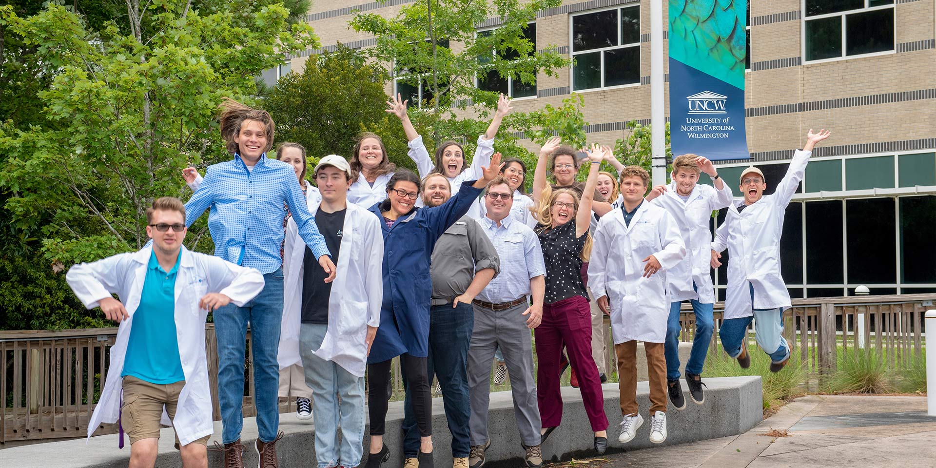 A group of people in lab coats jumping outside