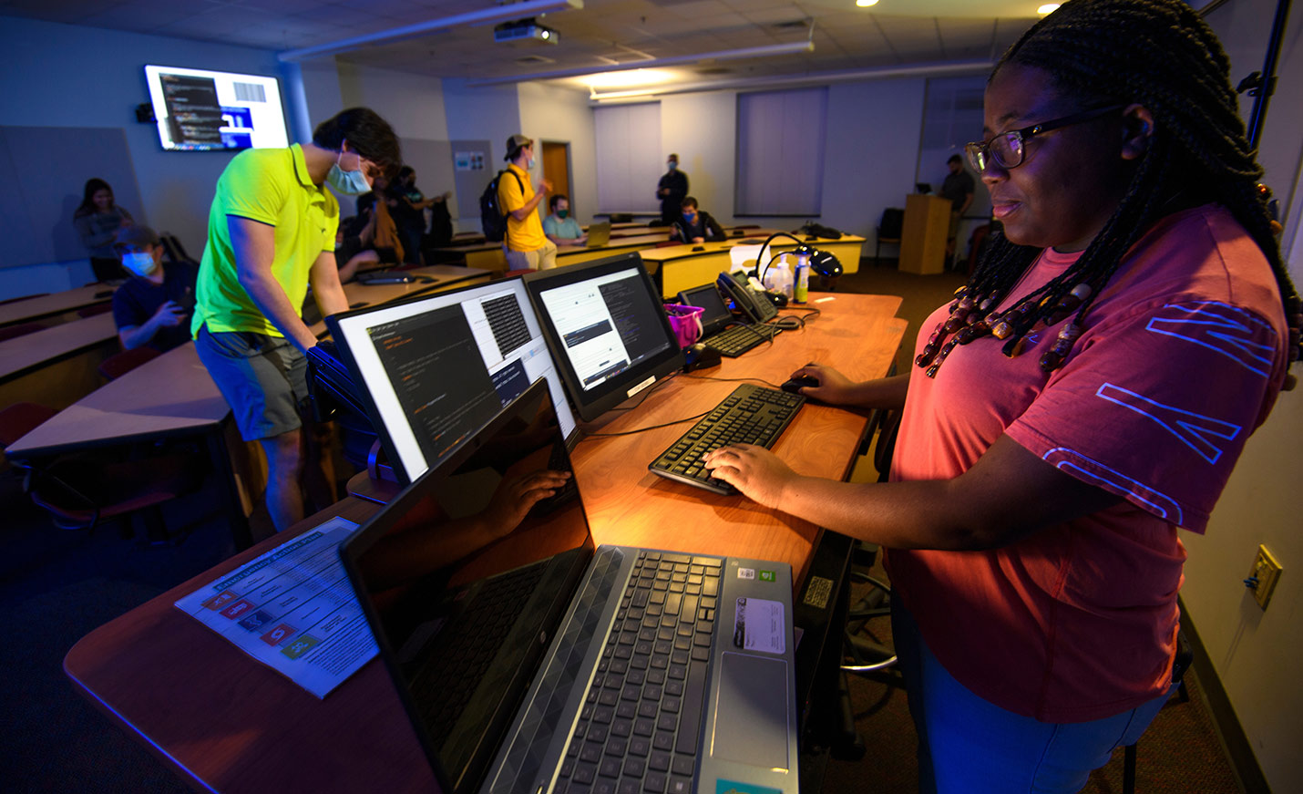 Students work in a large computer lab classroom