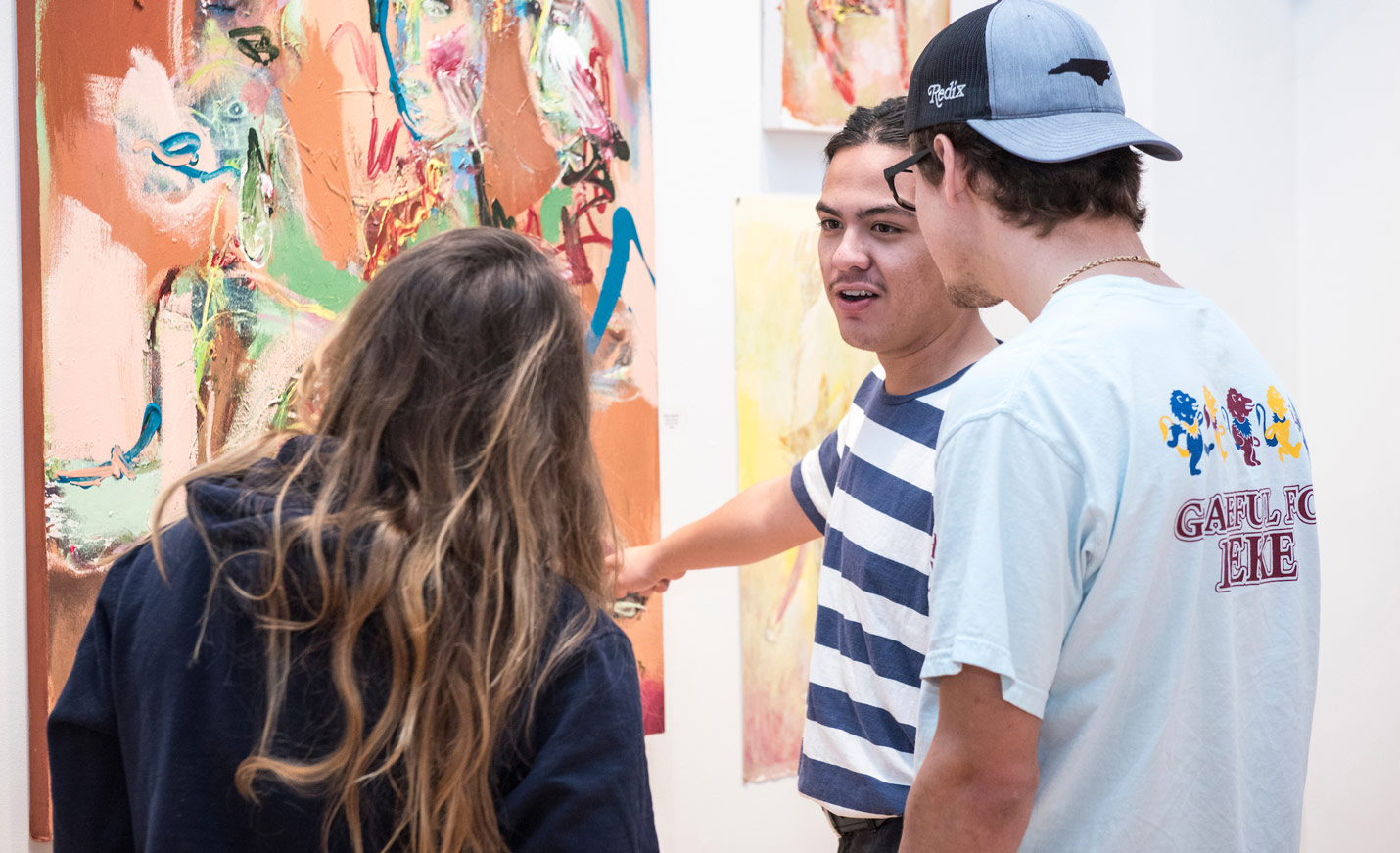 People looking at painting in art exhibit