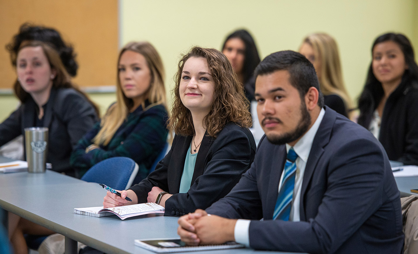 Students seated at tables in a lecture hall