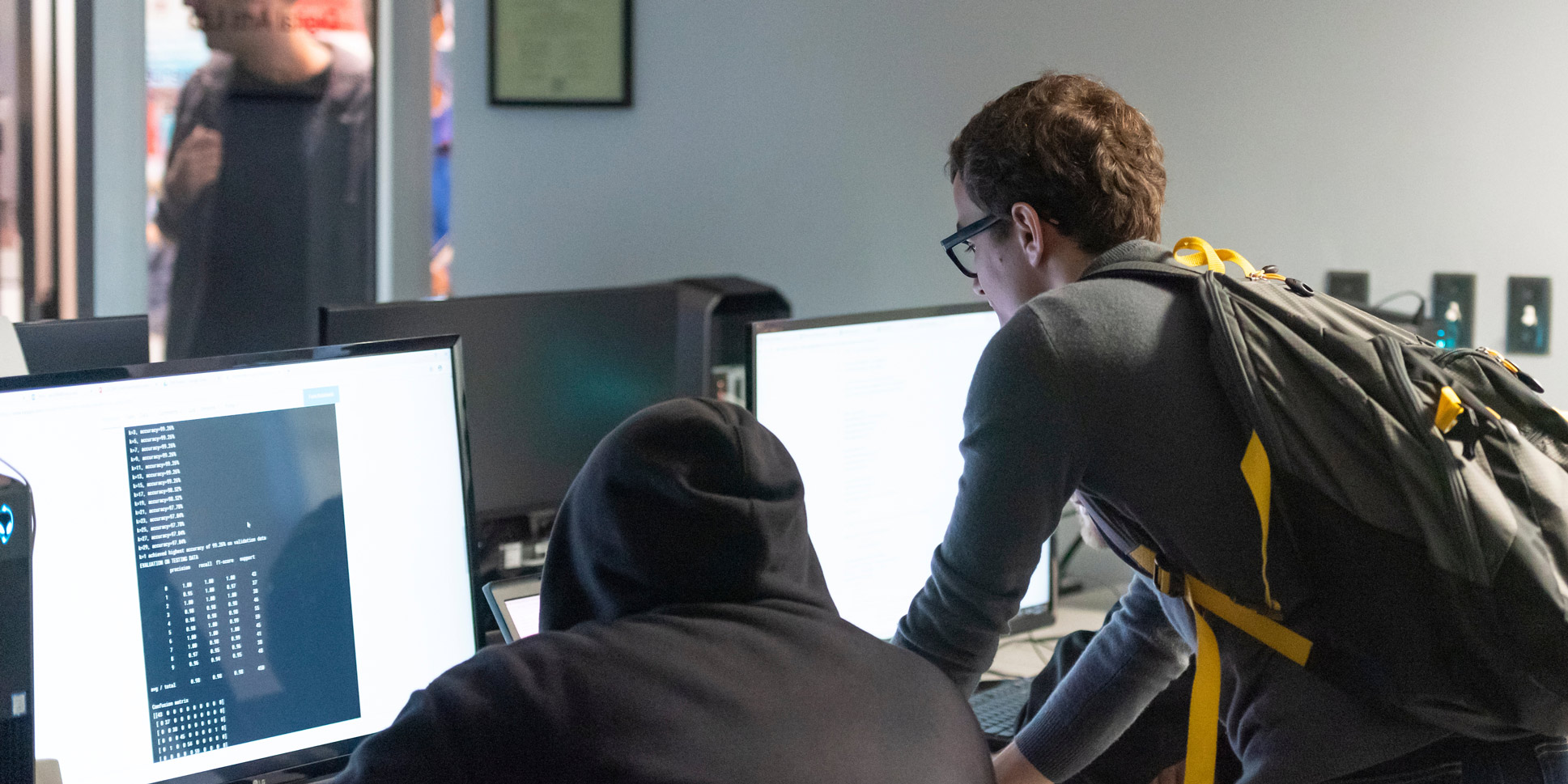 Two students work on a computer that has a large amount of numbers