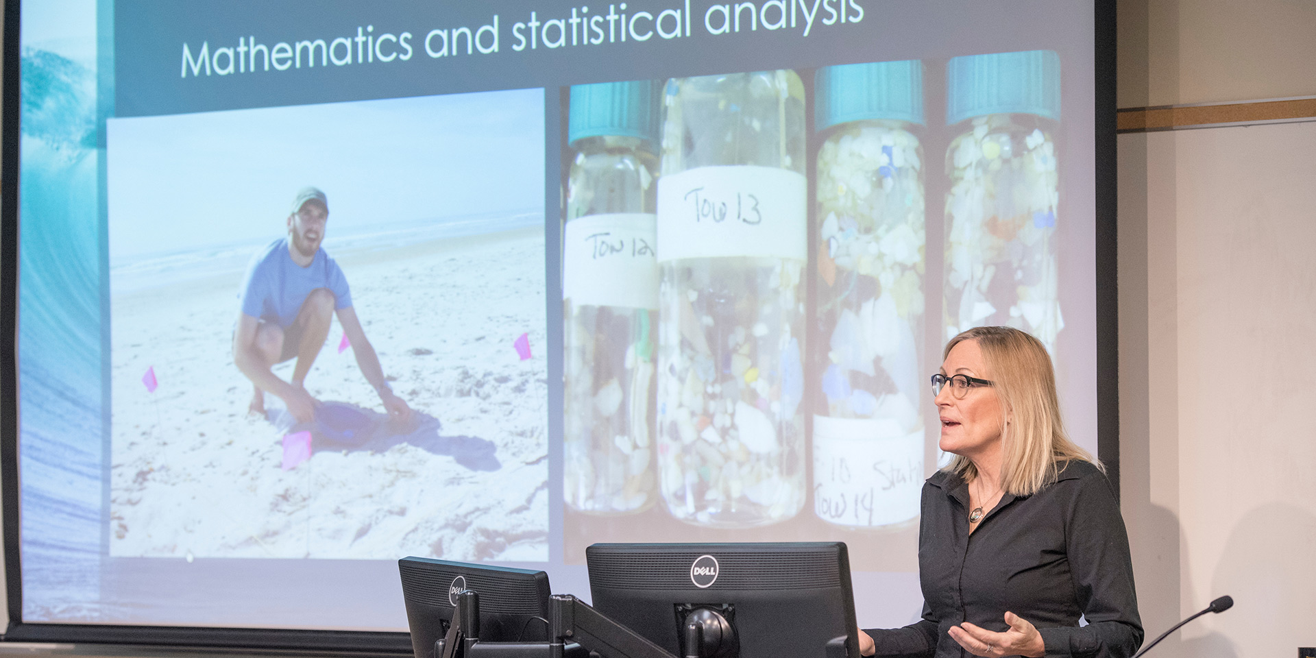 A professor giving a presentation with a slide that reads “Mathematics and Statistical Analysis”