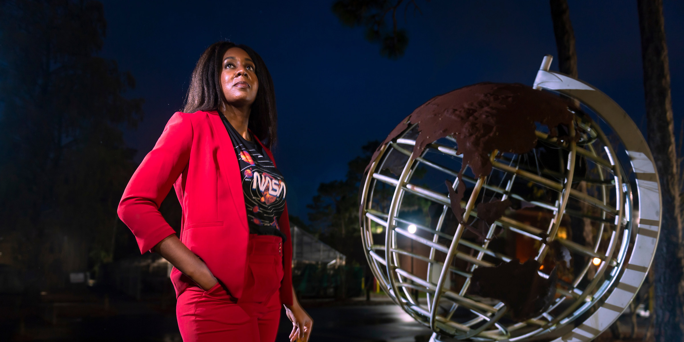 Woman standing in front of a metal globe
