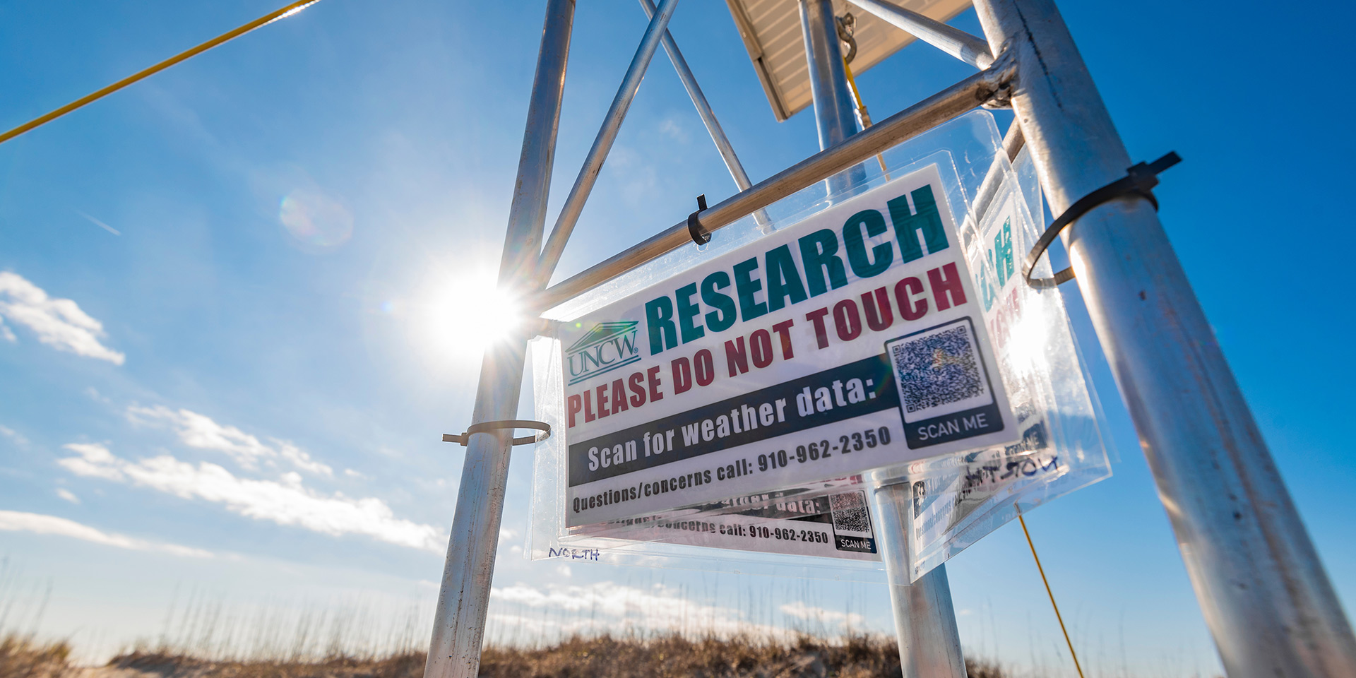 A UNCW weather tower with a sign warning people not to touch