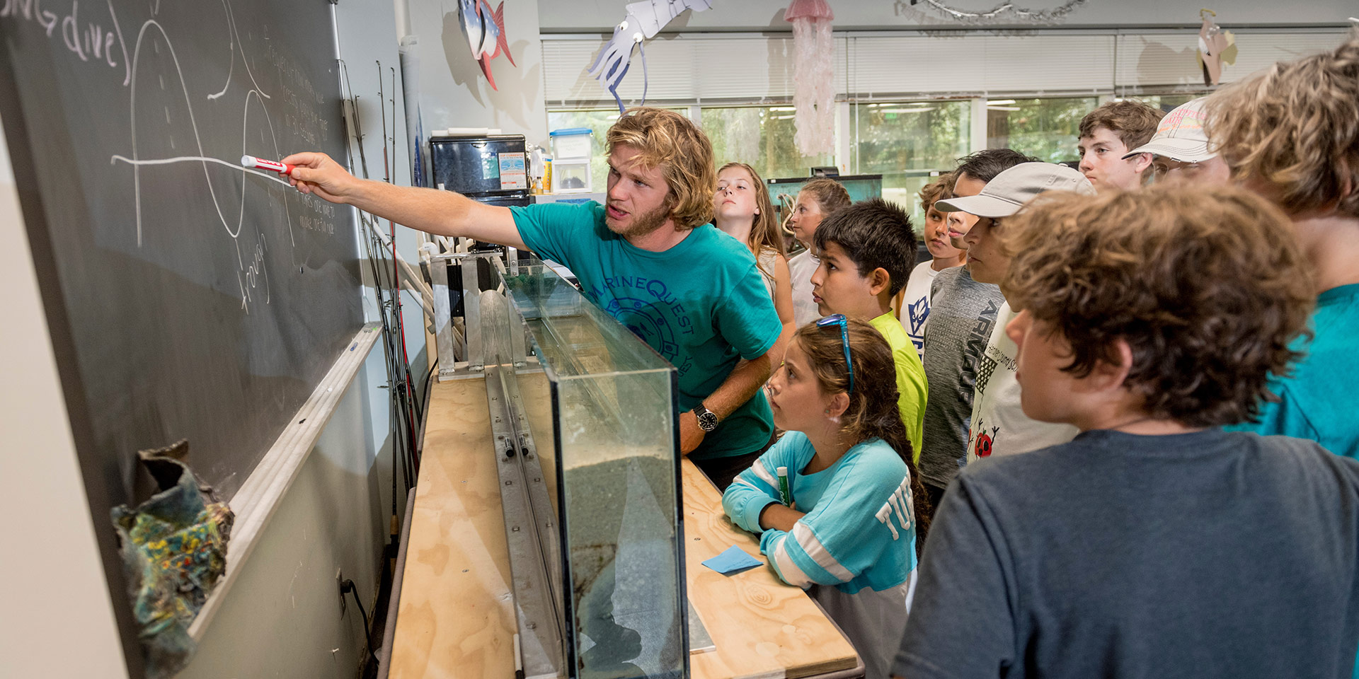 A student teaches a group of kids about physics