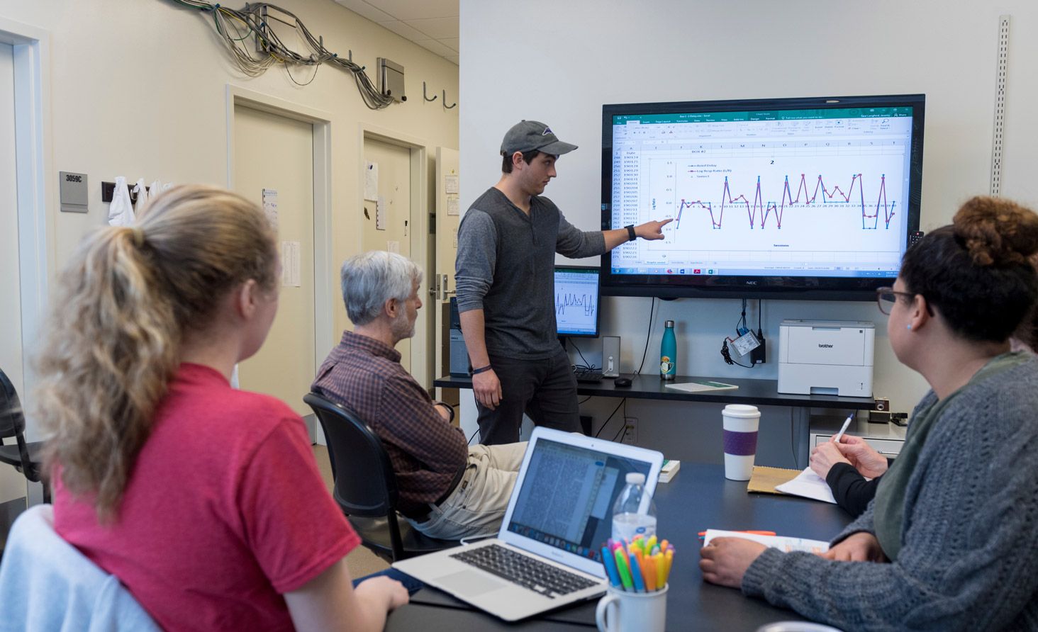 student pointing to graph on computer screen