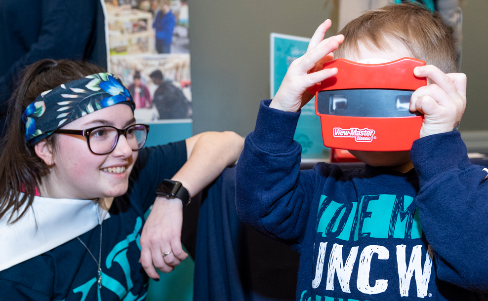 Three Watson students wearing a Superman-esuq UNCW cape