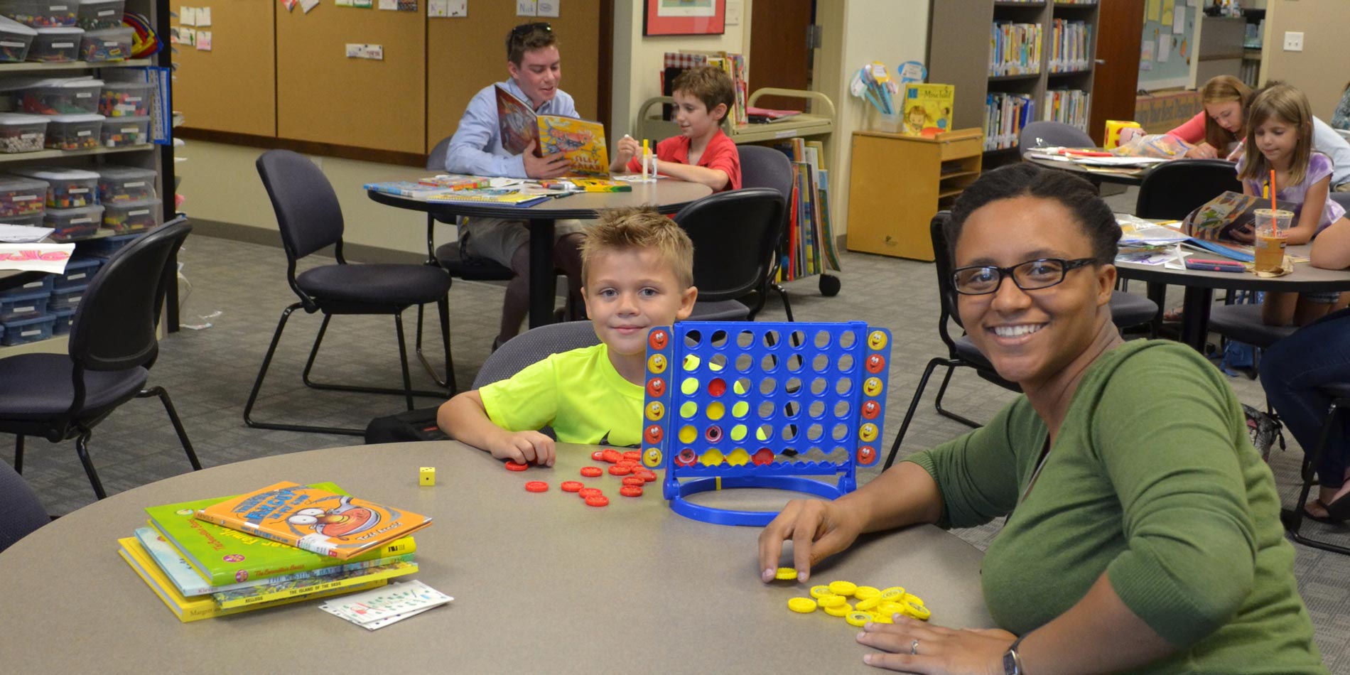 Watson student and elementary student playing connect 4