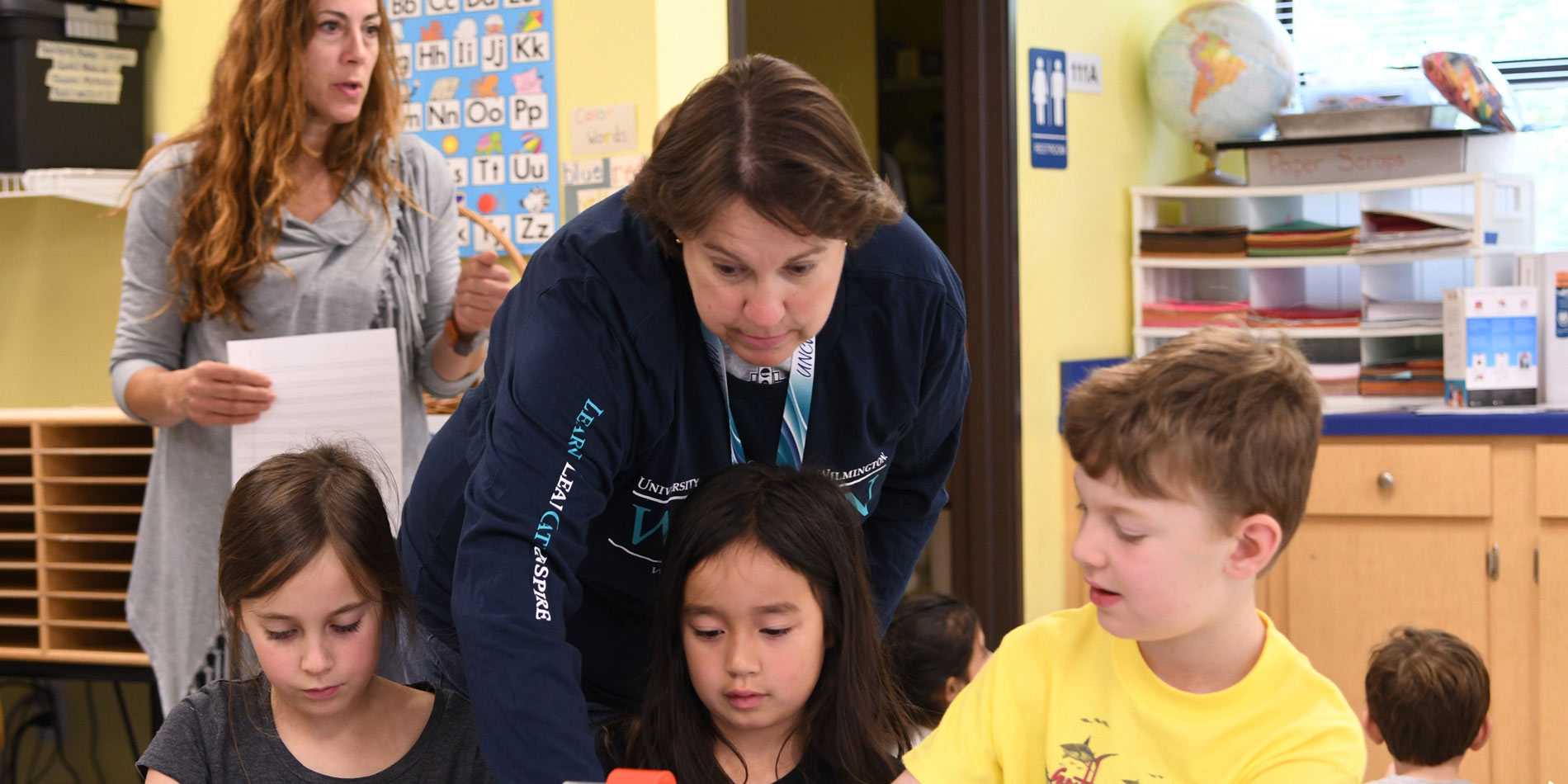 Teacher showing students how to use an iPad