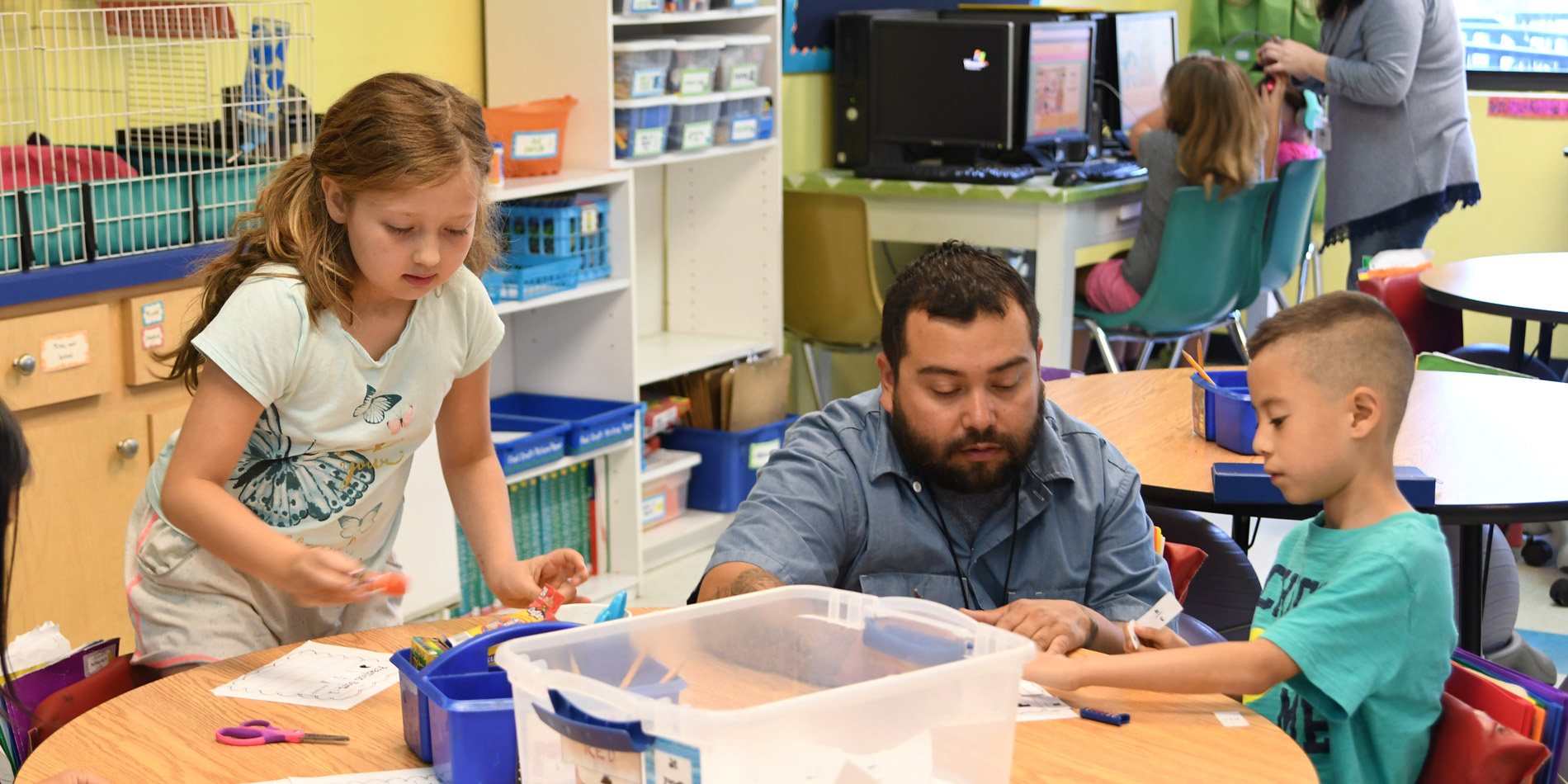 Teacher helping two students with math work