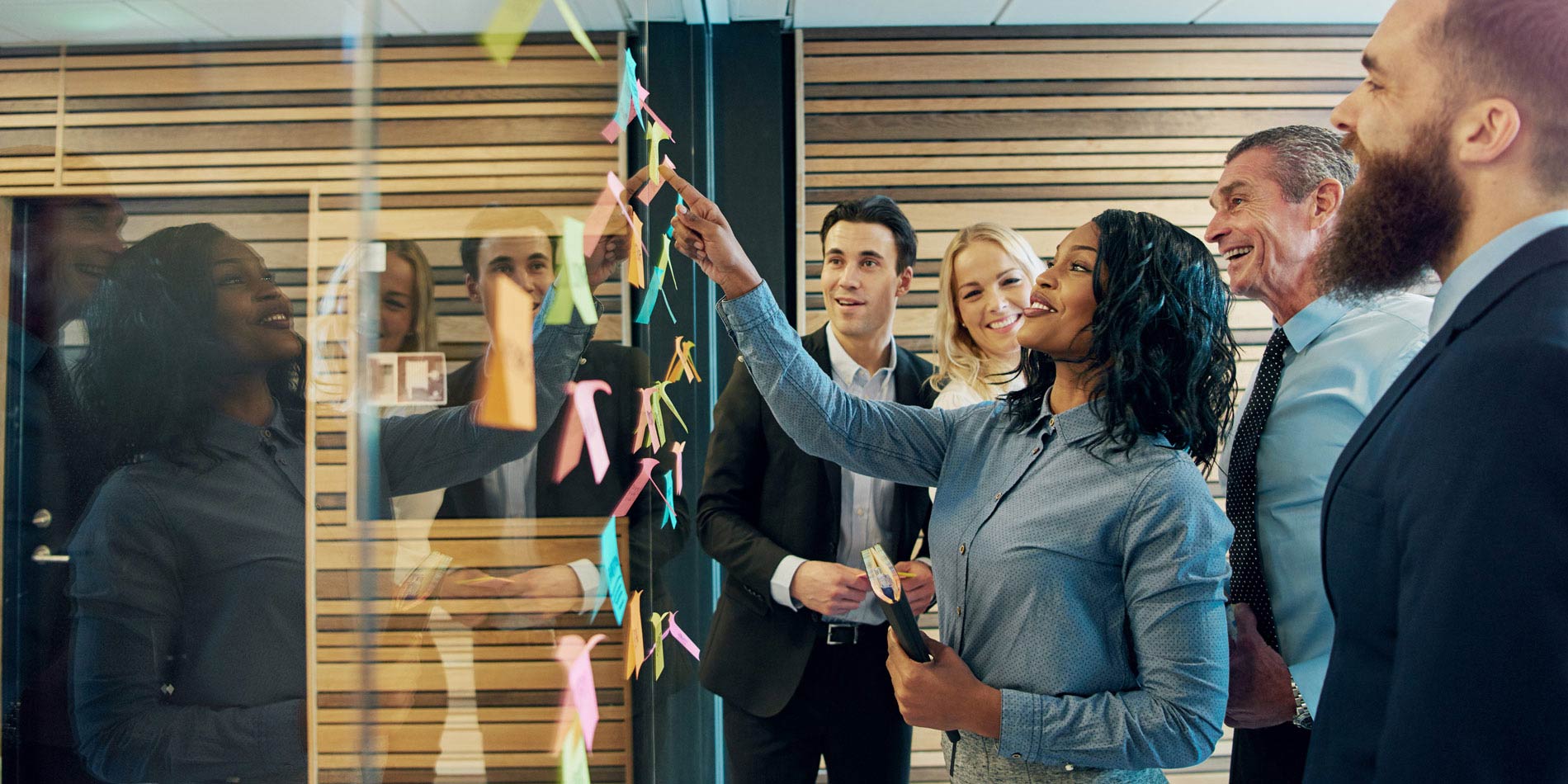 Executives putting sticky notes on a wall