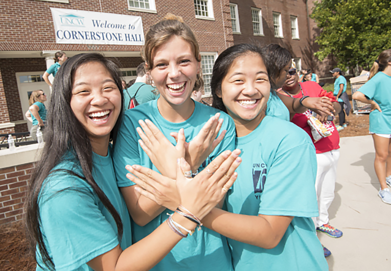 Three students stand outside of Cornerstone Hall.