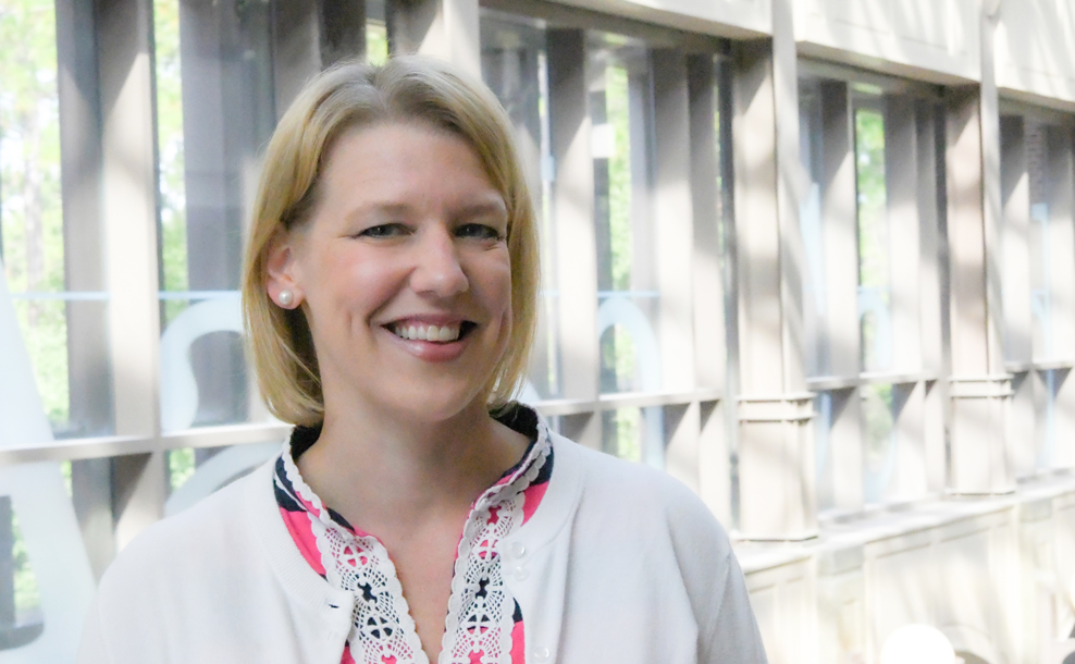 Portrait of Dr. Kate Taylor wearing a white top and pearl earrings