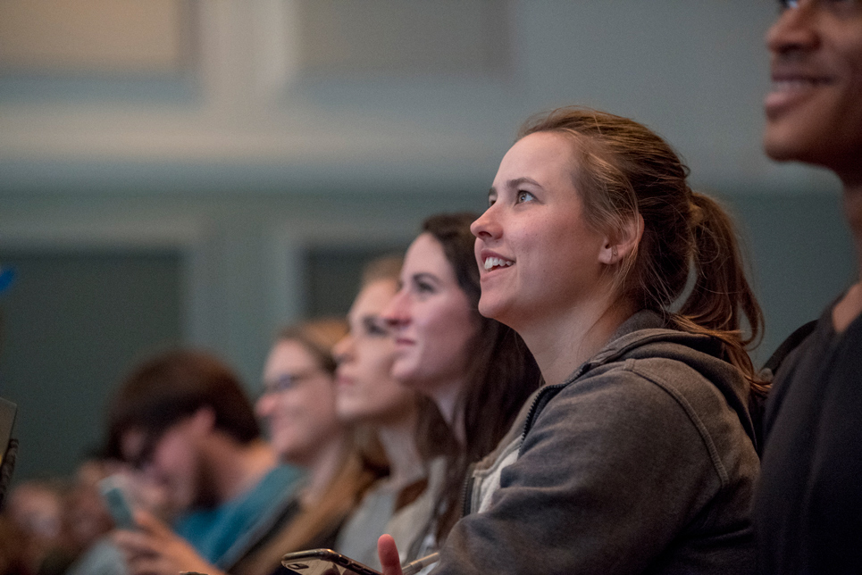 Students sitting in a conference looking onward