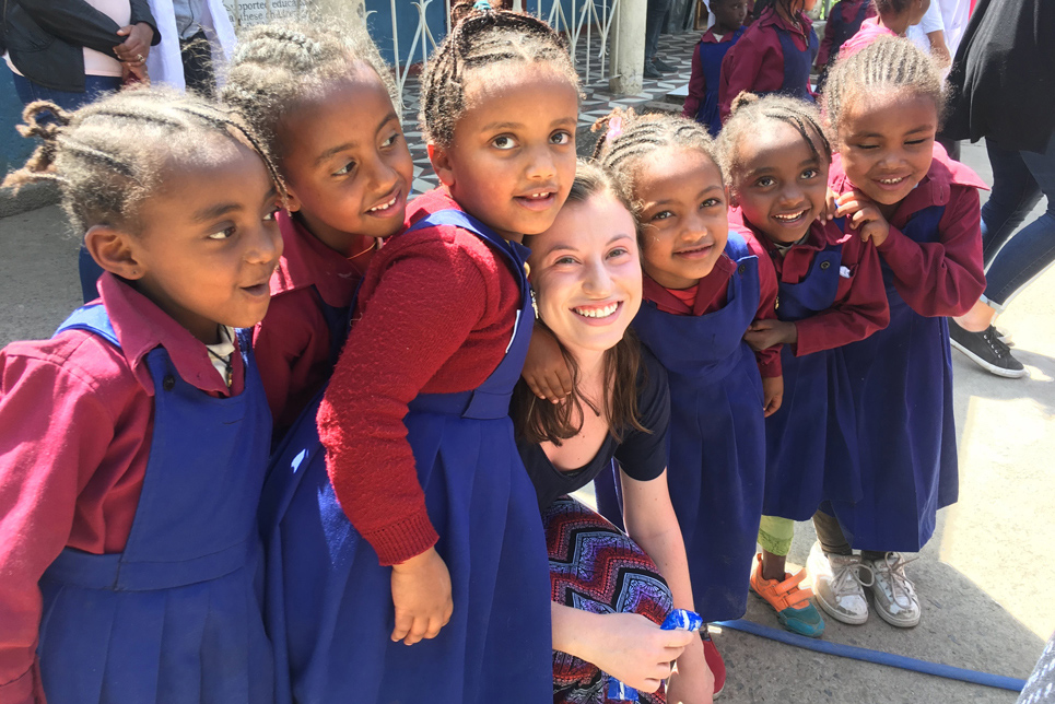 Watson student with a group of foreign elementary students