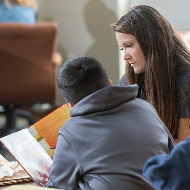 Student reads a book to youth