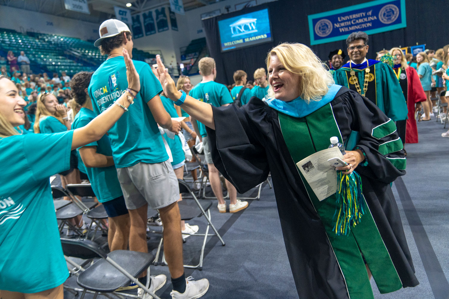 Freshman and Graduating student high fiving