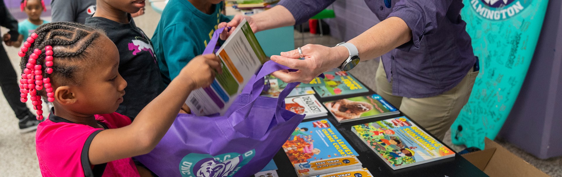 Handing students books and supplies