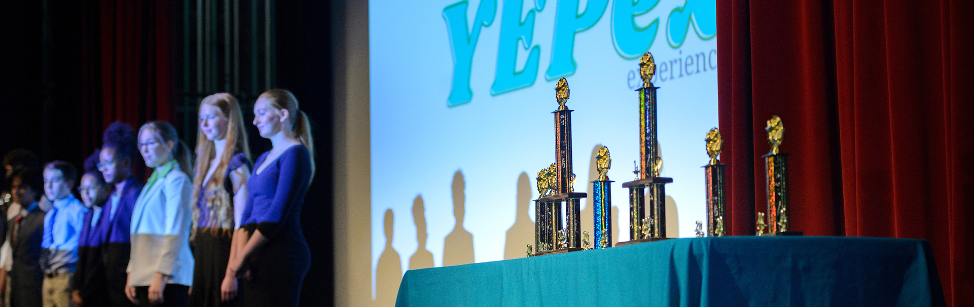 Students on stage with trophies.