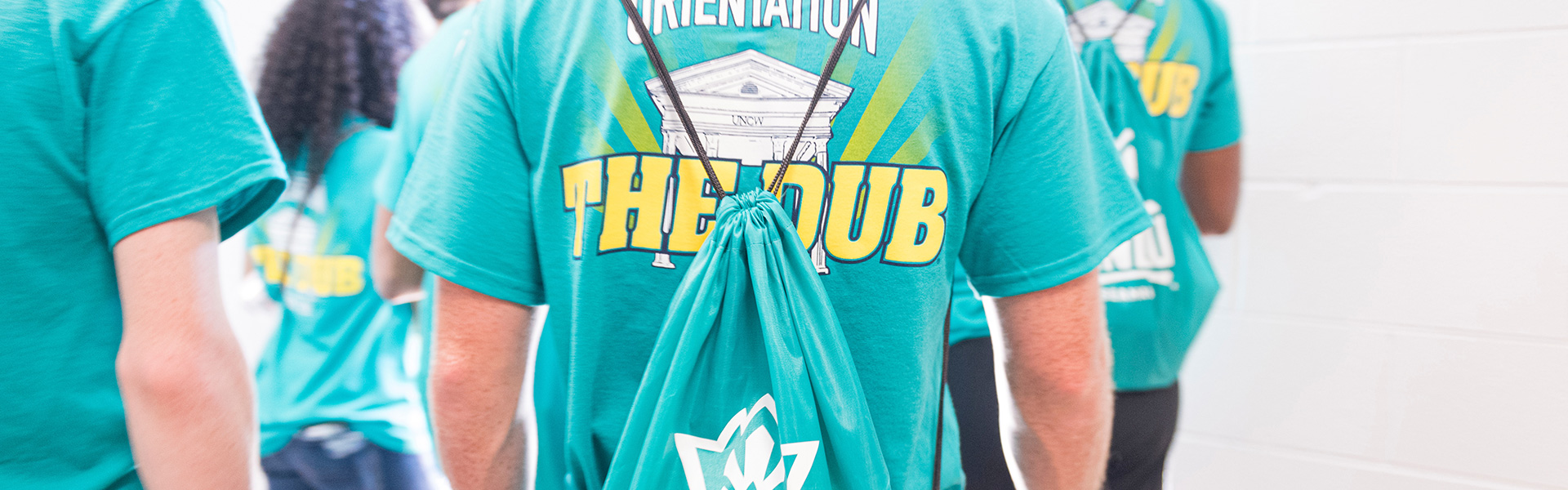 Students are lined up wearing teal orientation UNCW shirts for 2019 convocation